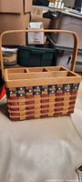 Full view of the rectangular woven basket showing four internal compartments and attached handle with patriotic colors.