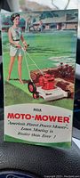 Front cover of brochure showing a woman pushing a red and white Moto-Mower on a suburban lawn.
