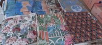 Several colorful heavy fabric panels laid out showing floral, bird, and geometric designs