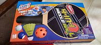 Box front showing the Whamo brand and the Pickle Ball 4 in 1 Set with images of paddles and balls included.
