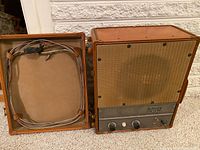 Overview of Ampex Model 620 amplifier and speaker combo with cables inside case lid
