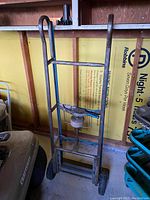 Front view of the vintage steel hand truck dolly showing the frame and wheels.