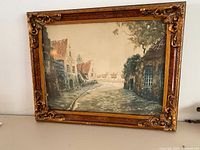 Full view of the framed watercolour painting showing architectural street scene with old buildings and paved road.