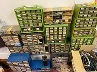 Wide view of lot showing multiple storage cabinets and drawers in various colors filled with hardware and small parts