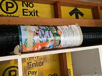 Full view of rolled green plastic garden netting with original packaging showing branding and usage instructions