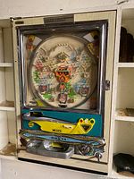 Full front view of the pachinko machine mounted in wooden frame