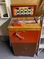 Overall view of slot machine on wood cabinet with lever extended, front and side visible