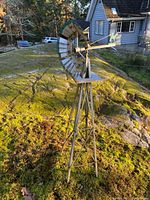 Full view of the vintage wind turbine mounted on a tripod stand in an outdoor setting.