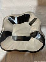 Top view of asymmetrical stainless steel dish showing reflective surface and organic shape.