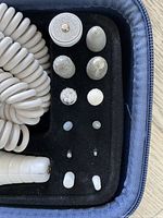 Close up of pedicure set grinding and polishing heads and replacement caps stored in case.