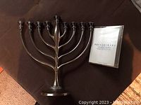Silver color Pottery Barn menorah with nine candle holders and accompanying Chanukah candles and instruction pamphlet.