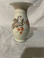Front view showing the painted floral designs and overall shape of the vase.