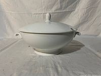 Front and side view of white porcelain soup tureen with lid on.