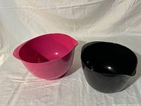 Pink and black Rosti Margarethe mixing bowls side by side on white background, showing shapes and colors