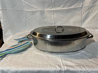 Photo of the stainless steel fish steamer with lid and two colorful ceramic fish-shaped spoon rests.