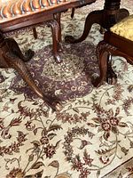 Close-up photo showing detailed floral pattern and furniture legs on the rug.