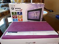 Digital 2 9 inch Pad Deluxe II tablet box and purple protective case on a table