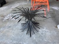 Angled view of the full table showing glass top and wheat grass motif metal base