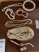 Overview of most items in the set showing necklaces, bracelet, and earrings on wooden surface
