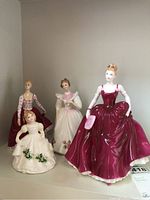 Front view of the four Royal Doulton figurines on a shelf showing detailed dresses and facial features