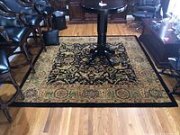 Square wool area rug in an office setting, showing detailed design, color, and condition