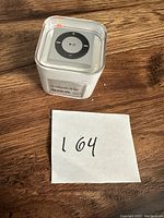 Apple iPod Shuffle 2GB in sealed clear plastic cube case showing front with control pad visible.