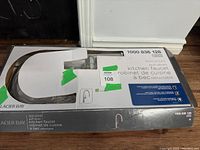Photo of the Mistos 1000 836 128 kitchen faucet in original packaging showing part of the faucet and packaging details with green tape and lot number.