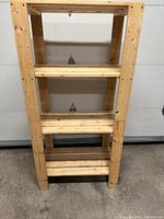 Front view of the used Ikea wooden shelf showing four shelves and light wood finish, highlighting its size and condition.