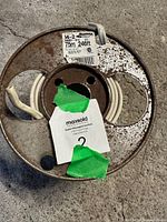 Photo of roll of 14-2 Romex wire on metal reel showing worn and rusted reel with wire extending from the center.