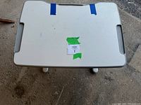 Top view of white rectangular children's desk surface with integrated handles and paper roll holder, showing minor wear marks.