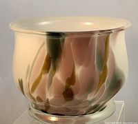 Front and angled view of translucent art glass bowl showing fluid vertical color streaks in pink, gray, and brown on a white background.