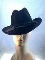 Front angle view of the black fur felt fedora hat with patent leather band on mannequin head.