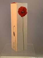 Front and side view of textured beige box with tall red poppy flower design