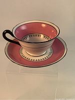 Side view of vintage Grosvenor China tea cup and matching saucer showing pink and black detailing on white porcelain