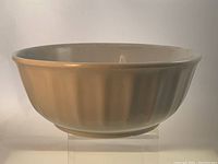 Side view of the large round white mixing bowl showing the fluted exterior surface and rolled rim.