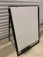 Whiteboard showing front surface and metal frame with slight writing visible.