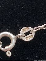 Close-up of the clasp and hallmark of the necklace showing the 925 sterling silver mark and Spanish origin stamps.