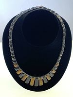 Front view of the full bib style necklace showing alternating butterscotch and black toned rectangular stones set in silver.