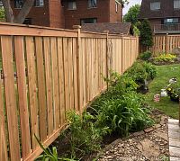 Wooden fence panels installed adjacent to garden showing sample of fencing service