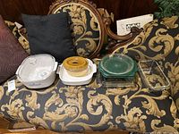Overview of all bakeware pieces on patterned couch showing ceramic and glass dishes