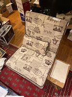 Full view of the Paris-themed upholstered accent chair with matching pillow and surrounding items.