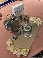 Overview of Lampe Berger lamp, refill box, Mickey Mouse clock, and decorative mirror plate on table