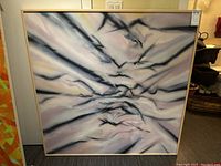 Full frontal view of the square framed abstract artwork leaning against a wall.