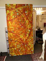 Full view of large abstract painting with warm colors and teal blue spots.