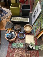 Overview of all planters, pots, gardening supplies including lantern, baskets, trays with artificial succulents.