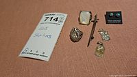 Photo showing all jewelry items including 2 rings, earrings, 2 charms, 3-inch sword pin, and the 925 sterling silver tag.