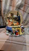 Photo of Kirkland Signature Christmas musical water globe with detailed painted holiday scene inside and on base, showing overall condition and features