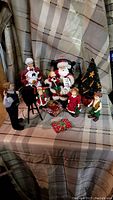 Full view of the Santa Claus display set including all figurines, Christmas tree, gifts, and photographer.