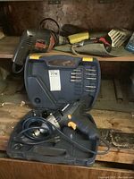 Photo showing Mastercraft Impact Wrench in blue case alongside drill bits and wooden shelf background