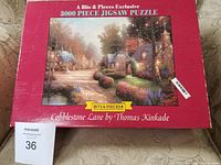 Puzzle box front showing the artwork image titled Cobblestone Lane by Thomas Kinkade with red border and brand Bits & Pieces logo.